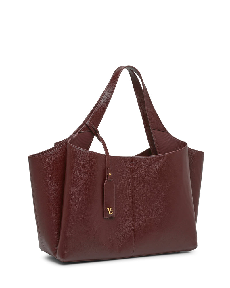 Large burgundy leather Gilda Tote Bag by Vince Camuto, featuring double handles and a gold logo tag, elegantly displayed on a white background.