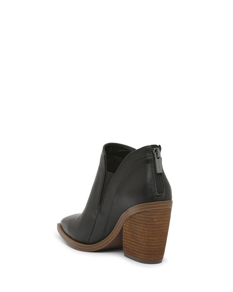 The Vince Camuto Gradina Bootie is a black leather bootie for women, featuring a stacked brown block heel, a stylish side cutout, and a visible back zipper, shown against a white background.