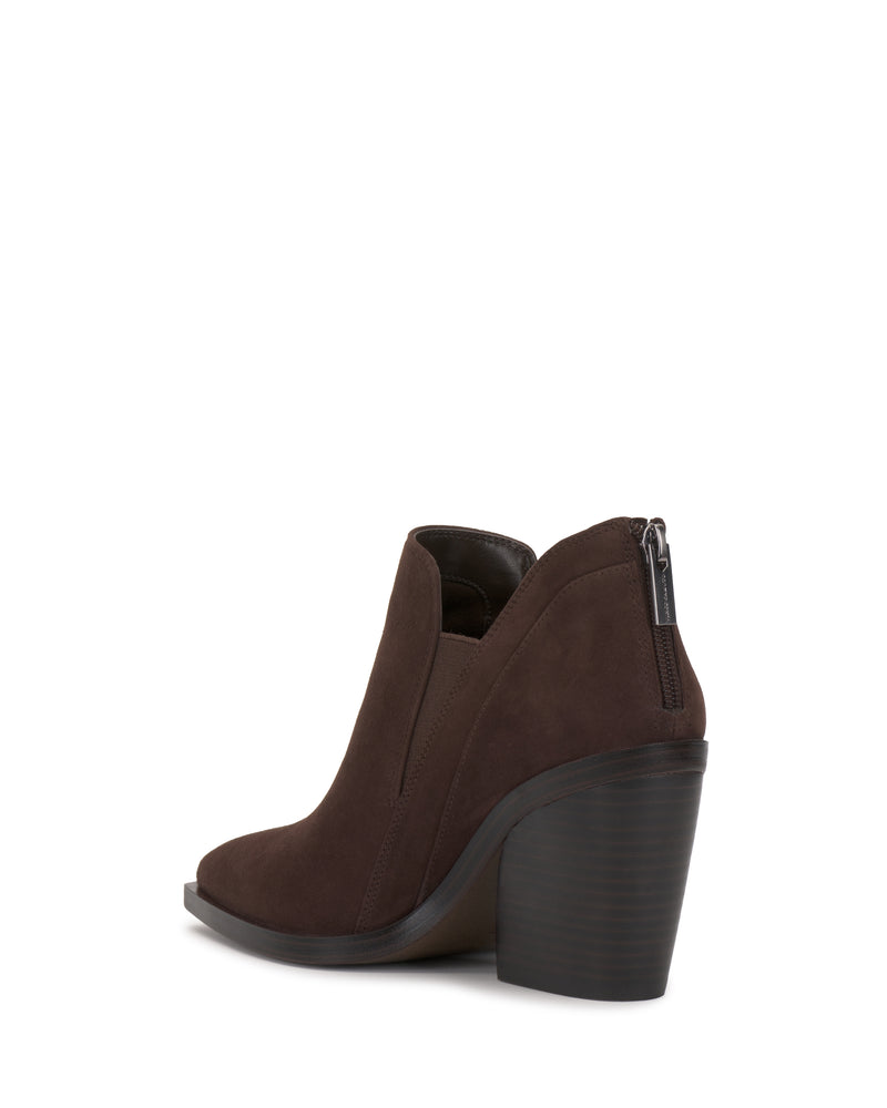 The Vince Camuto Gradina Bootie is a dark brown suede ankle boot featuring a chunky high heel, side cutouts, and a back zipper, displayed on a white background.