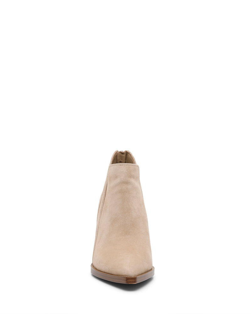 Front view of the Gradina Bootie by Vince Camuto in beige suede, featuring a pointed toe, low block heel, and side zipper detail. This stylish women’s ankle boot with a block heel design is elegantly displayed on a white background.