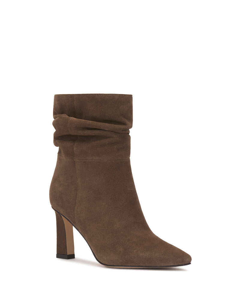 The Grenna Slouchy Bootie by Vince Camuto features brown suede, a pointed toe, a slouchy shaft, and a high block heel, showcased against a plain white background.