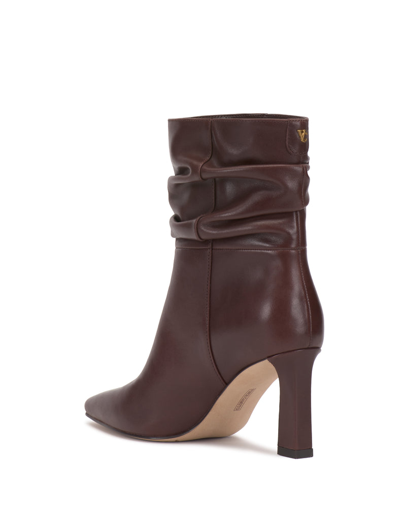 The Vince Camuto Grenna Slouchy Bootie is a single brown leather ankle boot featuring a slightly slouched shaft, pointed toe, and a modest heel, photographed against a white background.