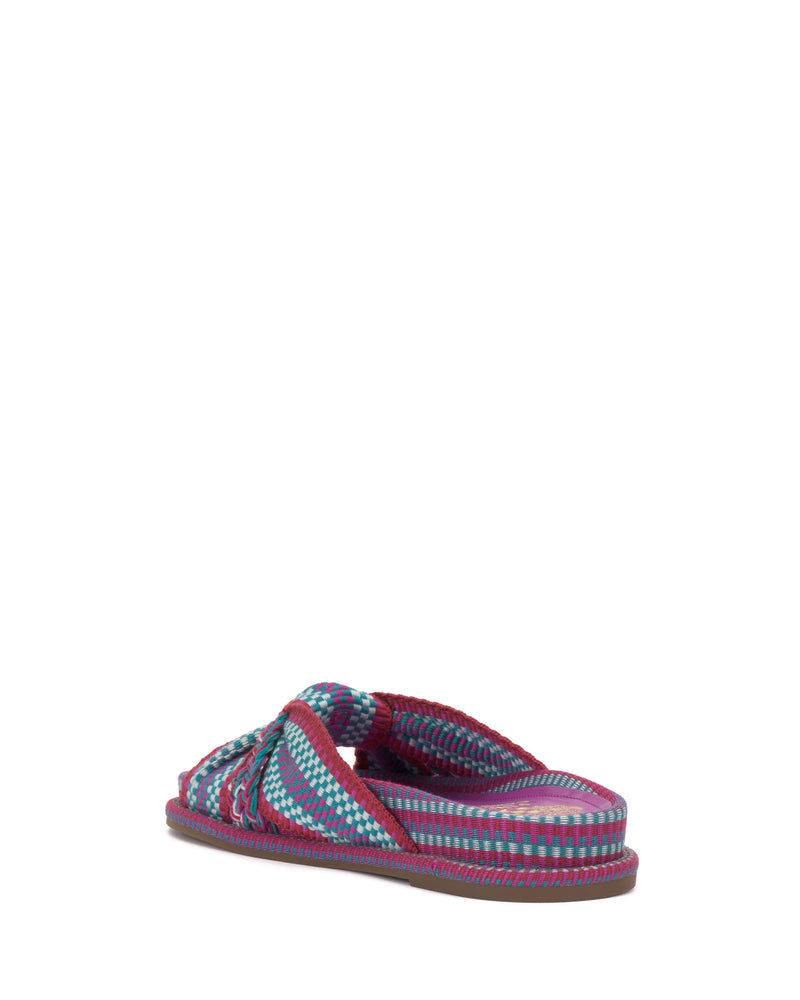 The Vince Camuto Gryfynn Slide is a colorful woven sandal with blue, pink, and purple stripes. Seen from the back at an angle on a white background, its braided strap and cushioned sole offer a comfortable, summery style.