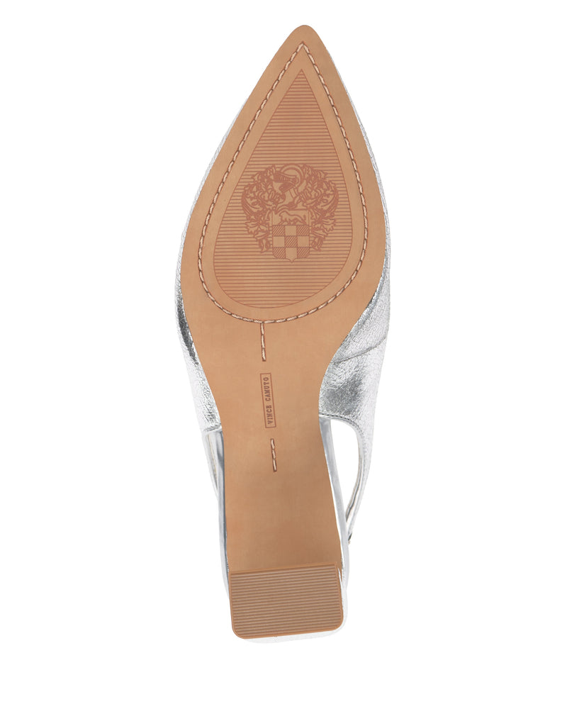 The image shows the sole of the Hamden Slingback by Vince Camuto, a leather point-toe pump featuring a tan bottom and an embossed crest design near the tip.