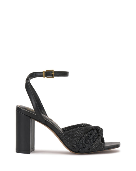 The Vince Camuto Hanlea Sandal showcases a black braided leather front strap, closed back, ankle strap with gold buckle, and a thick block heel for stylish support.