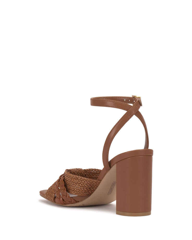 The Vince Camuto Hanlea Sandal showcases a brown open-toe design with braided front details, a thick block heel, and an ankle strap with buckle closure, displayed from the back.