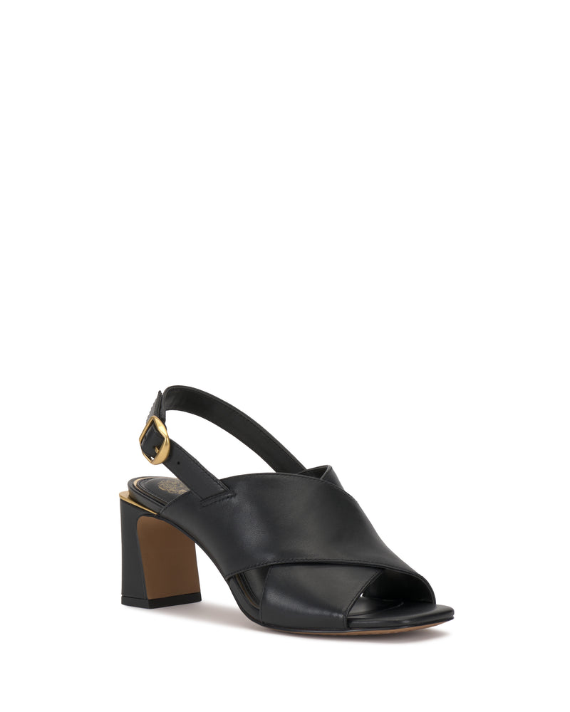 The Harlynn Sandal by Vince Camuto is a black, open-toe shoe with a block heel slingback, featuring wide cross-band straps at the front and an adjustable ankle strap with a gold buckle. Its sleek, modern design makes it perfect for any occasion.