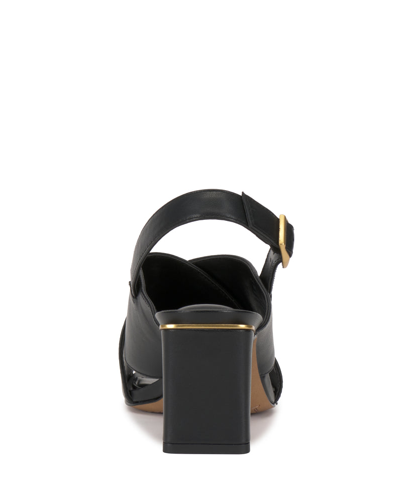 The Vince Camuto Harlynn Sandal in black is shown from the back, highlighting its thick block heel, ankle strap with a gold buckle, and elegant gold trim along the upper edge.