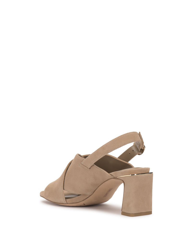 The Vince Camuto Harlynn Sandal in beige features a thick block heel, crisscross front straps, and an adjustable slingback strap. The open-toe sandal is displayed angled to the left on a white background.