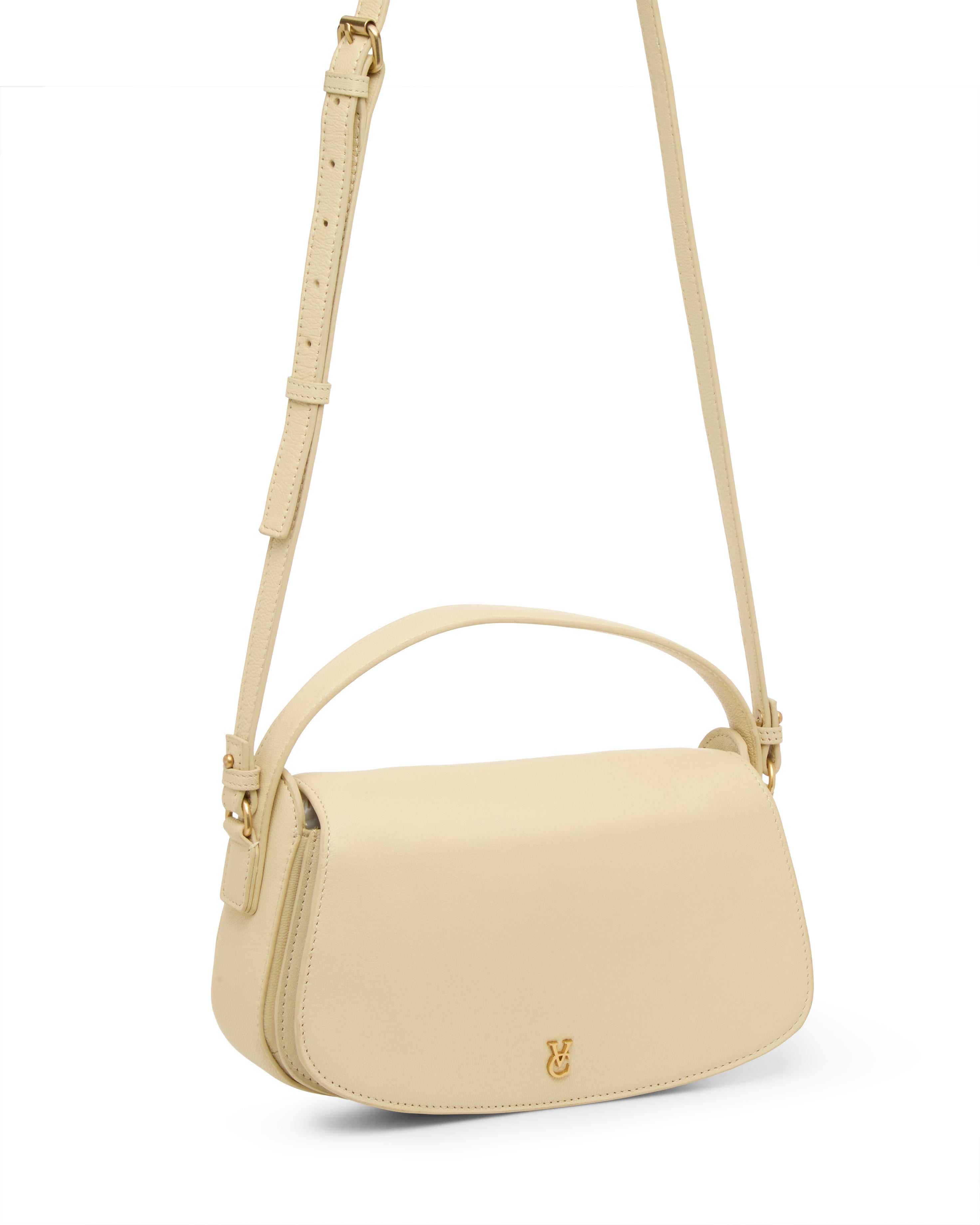 The Vince Camuto Jayda Crossbody Bag in beige nappa leather features a top handle, adjustable strap, and a small gold logo on the front flap.