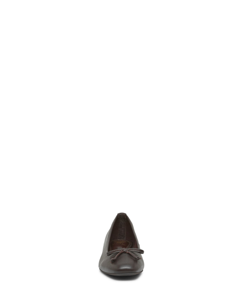 The Jenlea Ballet Flat by Vince Camuto is shown from the front against a plain white background, featuring a brown design with a small bow accent on the toe.