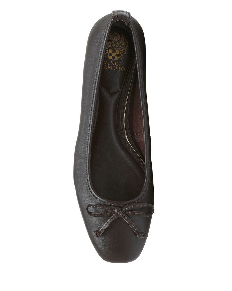 A top view of the Vince Camuto Jenlea Ballet Flat in dark brown, featuring a rounded square toe and a small bow accent on the front. The insole displays a gold Vince Camuto logo.