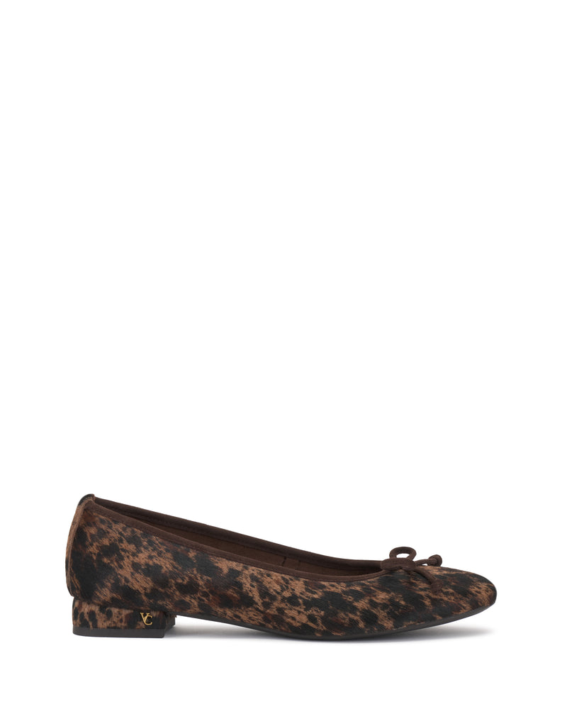 The Vince Camuto Jenlea Ballet Flat features a brown leopard print design with a small bow on the rounded toe and a short heel. A subtle gold Vince Camuto logo detail accents the outer heel, and the product is showcased against a plain white background.