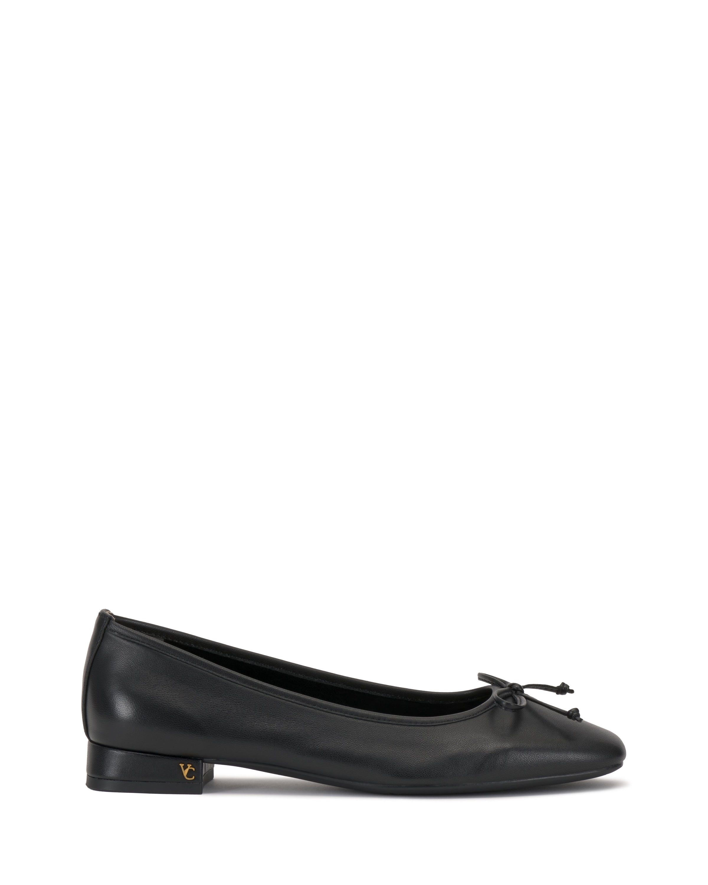 The Vince Camuto Jenlea Ballet Flat is a black leather shoe with a low block heel, bow accent on the rounded toe, and a subtle gold logo near the heel, shown against a white background.
