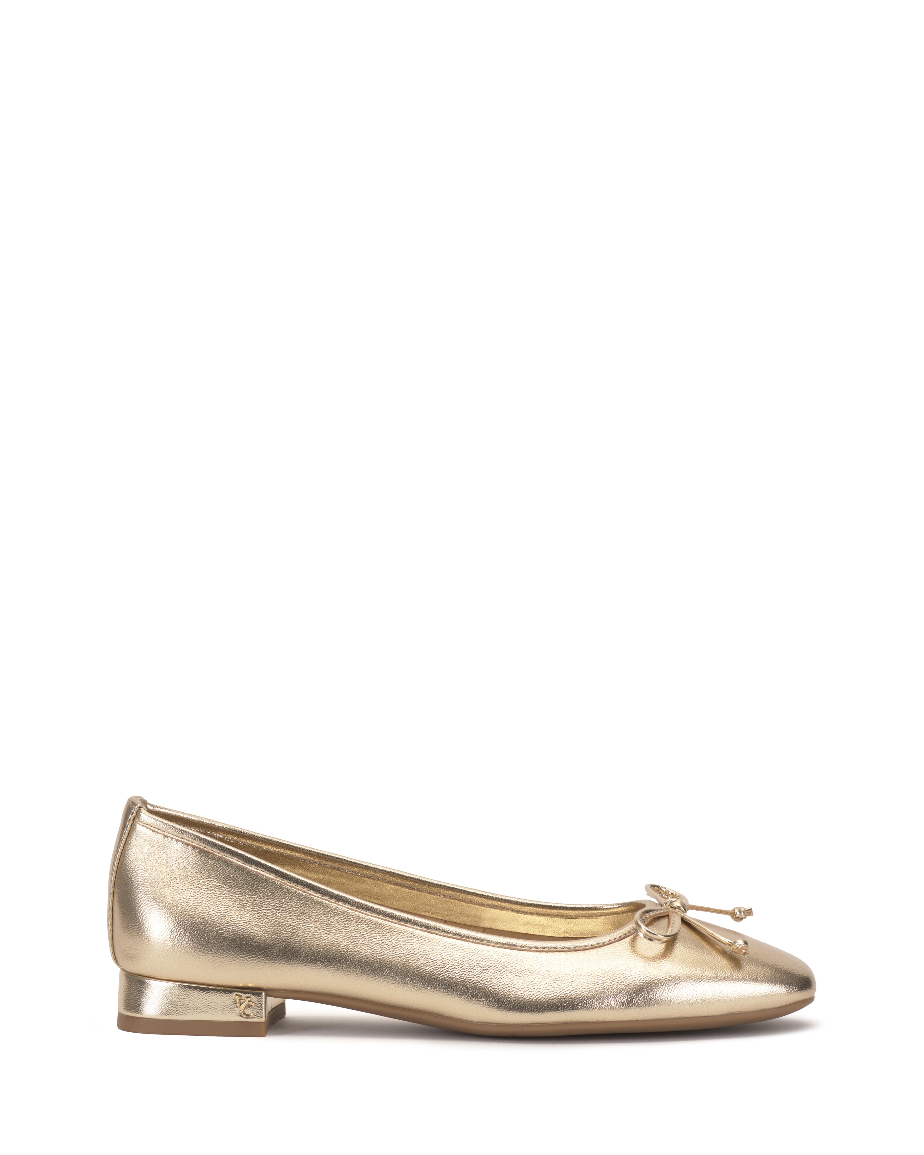 The Vince Camuto Jenlea Ballet Flat, in gold with a small toe bow and low block heel, is shown in side profile on a white background.