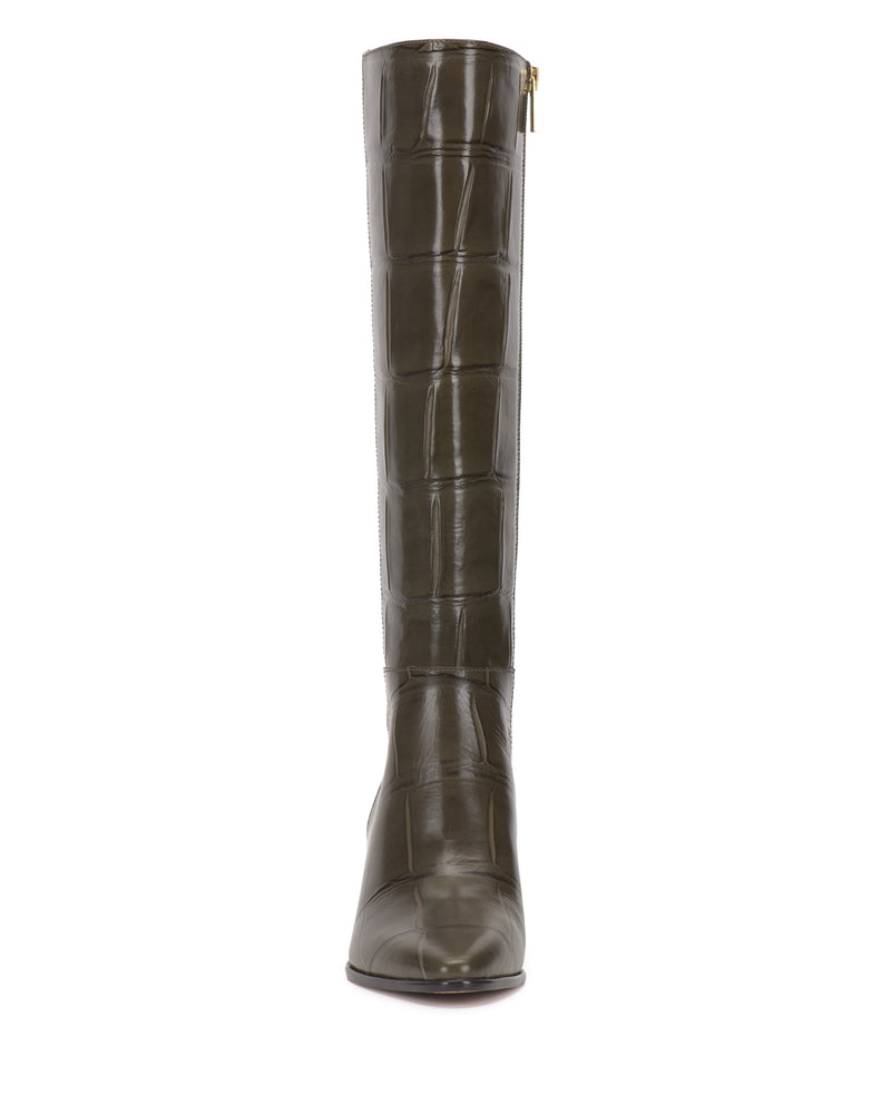 The Jorela Wide Calf Knee High Boot by Vince Camuto features a tall, dark brown silhouette with a glossy, crocodile-embossed texture. Viewed from the front, this boot shows off its pointed toe and slight heel, while a small side zipper adds functional detail.