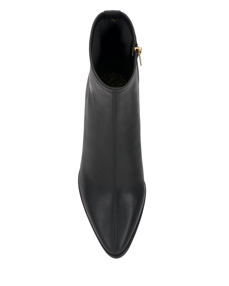 The Vince Camuto Julea Bootie in black leather is shown from above, highlighting its pointed toe, central seam, and a gold zipper detail on the side.
