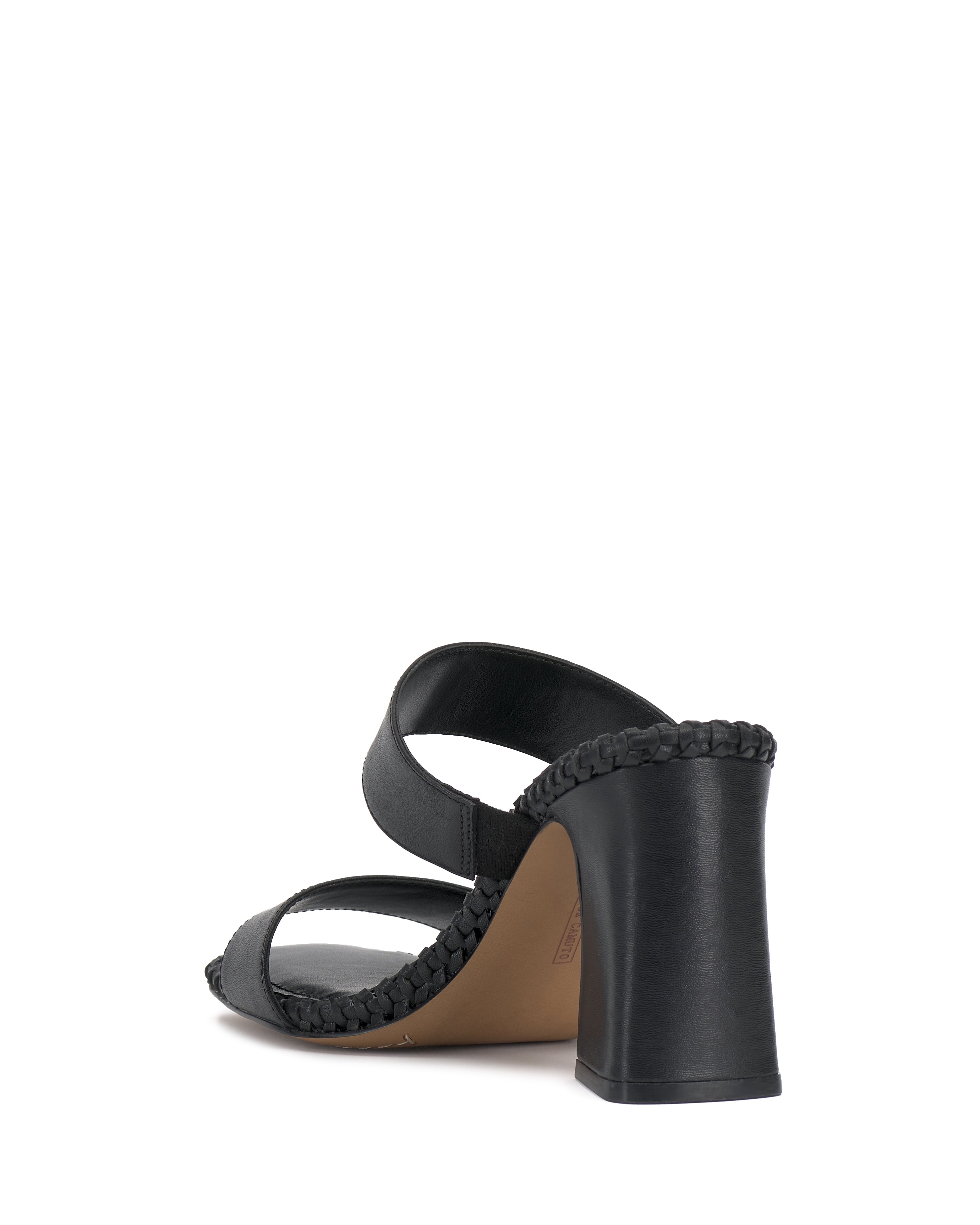 The Kaden Mule by Vince Camuto is a black block heel sandal with two wide straps and boho-inspired braided detailing along the edges, shown from the back at an angle on a white background.