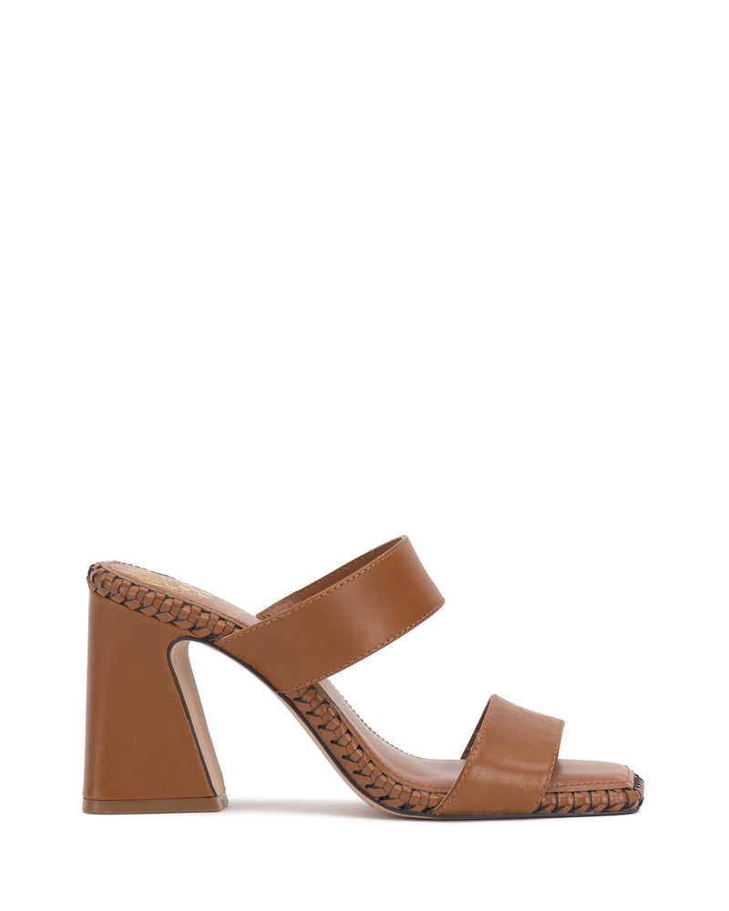 The Kaden Mule by Vince Camuto is a brown block heel sandal with a square toe, two wide straps, and woven detailing along the midsole. The sandal is photographed against a plain white background.