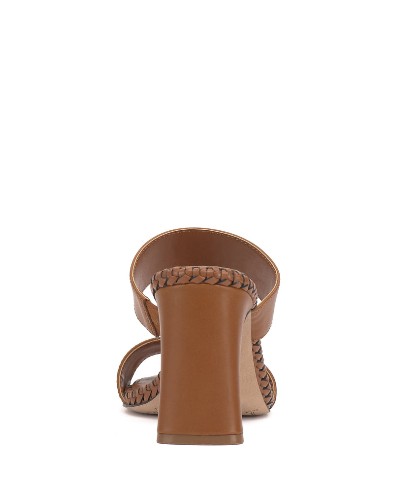 The Vince Camuto Kaden Mule is a brown block heel sandal, shown from the back, with braided trim around the heel, footbed, and ankle strap, plus a stylish square toe.