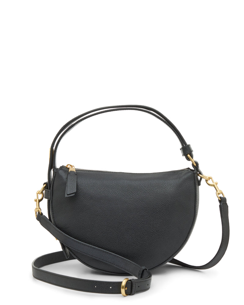 The Vince Camuto Karla Crossbody Bag features a black, half-moon leather design with gold hardware, a zip closure, a short handle, and an adjustable shoulder strap attached by gold rings.