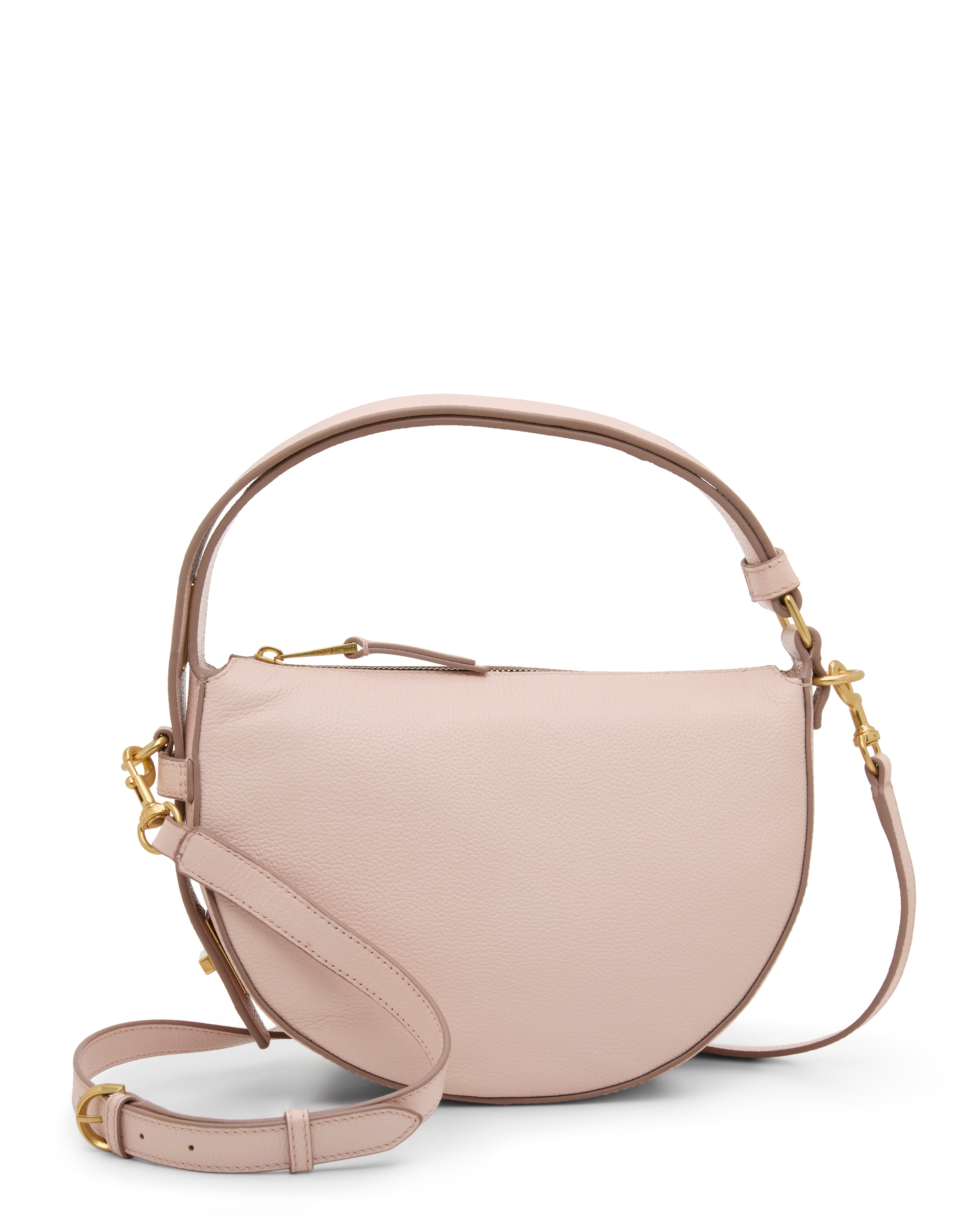 The Karla Crossbody Bag by Vince Camuto is a light pink, half-moon leather handbag with gold hardware, a top handle, and a detachable crossbody strap, shown standing upright against a plain white background.
