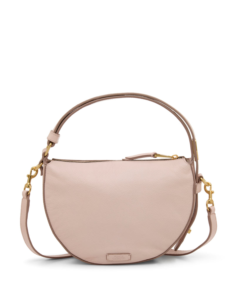 The Vince Camuto Karla Crossbody Bag is a blush pink, half-moon leather bag with gold hardware, top zipper, short handle, and adjustable crossbody strap. Its minimalistic design adds an elegant touch to any look.