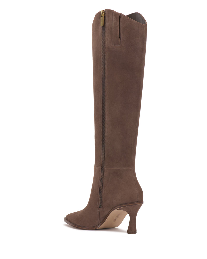 The Kenlea Narrow Calf Knee High Boot by Vince Camuto is shown in profile against a white background, featuring brown suede, a pointed toe, side zipper, and a curved high heel.