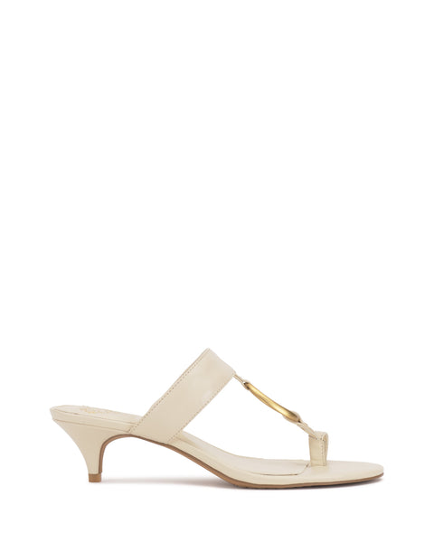 The Vince Camuto Kimena O-Ring Kitten Heel Sandal in beige features a T-strap design, toe loop, and gold metal accent on the upper strap, displayed against a plain white background.