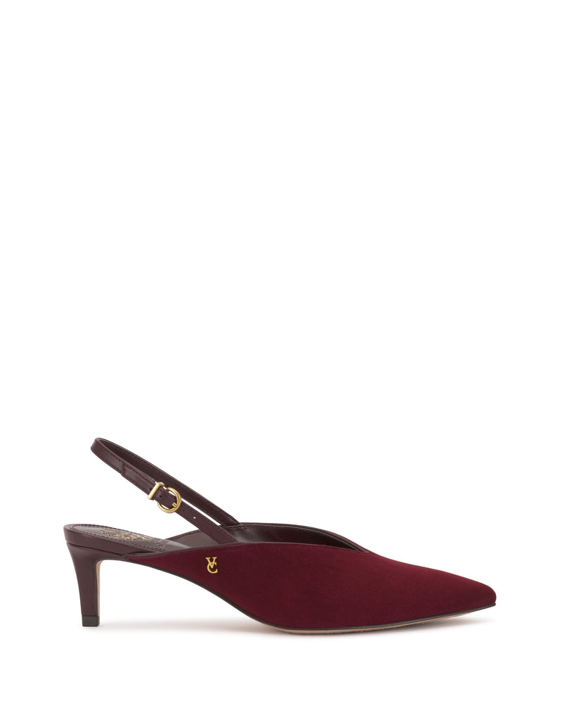 The Vince Camuto Kylien Kitten Heel Pump is a burgundy slingback with a pointed toe, slim kitten heel, and gold buckle strap. A small gold emblem accents the side near the heel. The shoe is shown against a plain white background.