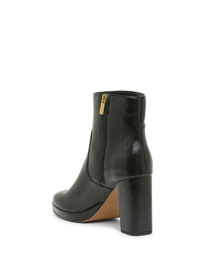 The Laylei Bootie by Vince Camuto features a shiny black leather finish, a chunky block heel, and a slightly rounded toe. It has a tan sole and is detailed with a side zipper featuring a gold pull. The bootie is shown angled to display both its back and side profile.