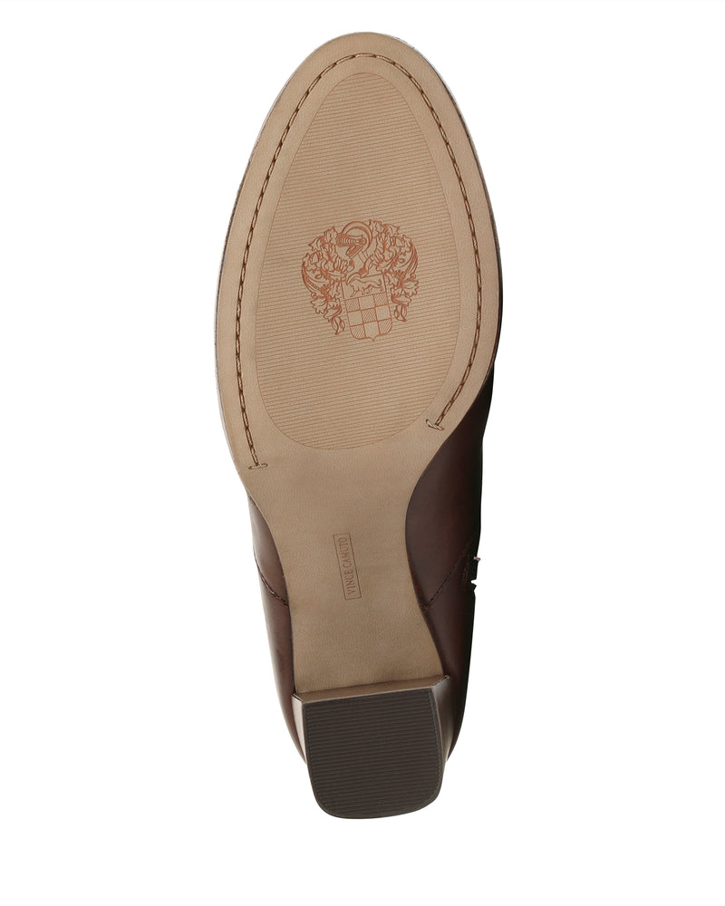 The Laylei Bootie by Vince Camuto features a brown sole with a textured oval area and an engraved crest or emblem at the center. Visible stitching traces the outer edge, while a squared block heel provides both stylish appeal and sturdy support.