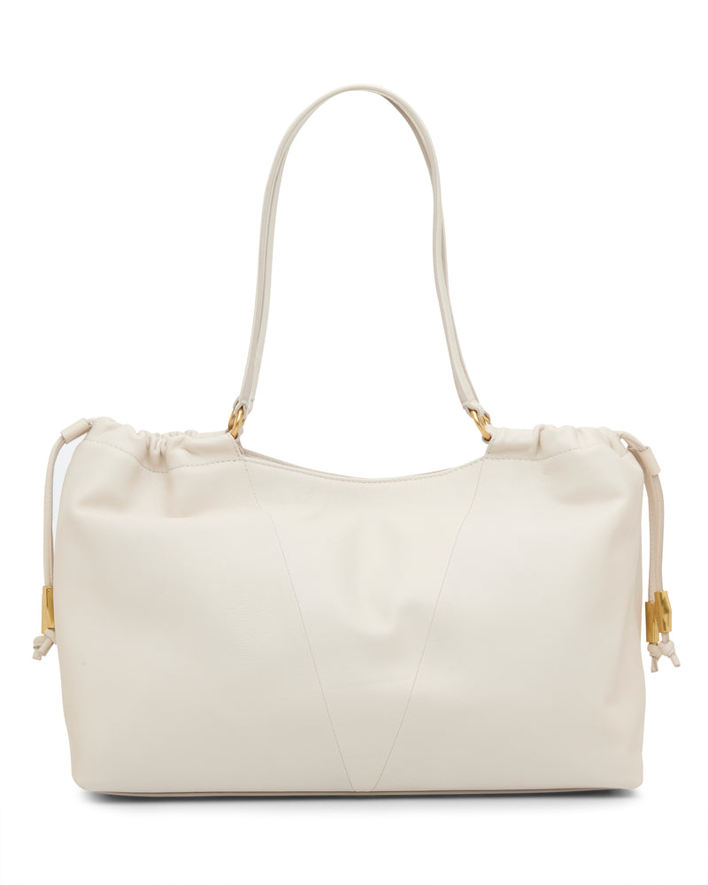 The Vince Camuto Leane Tote Bag, a cream-colored leather handbag with gold hardware, single shoulder strap, and side drawstring details, is displayed on a plain white background.
