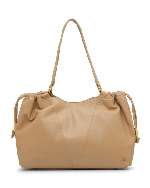 The Vince Camuto Leane Tote Bag is a tan leather shoulder bag with gathered top details, adjustable drawstring sides, dual straps, and a small gold logo at the lower right corner.