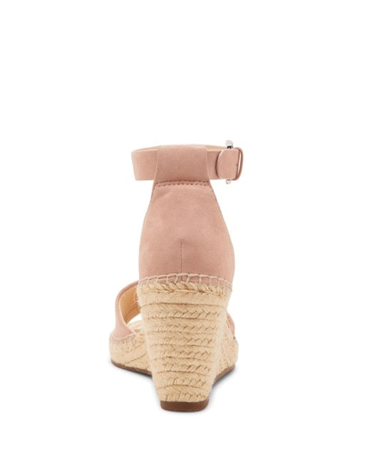A rear view of the Vince Camuto Leera Espadrille Wedge Sandal in blush pink, featuring an ankle strap and a braided jute heel, displayed on a white background.