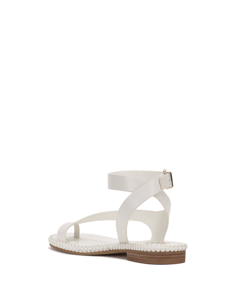 The Libahs Sandal by Vince Camuto is a white sandal with a braided sole, low wooden heel, adjustable buckle ankle strap, and crisscross design, shown from the back against a white background.