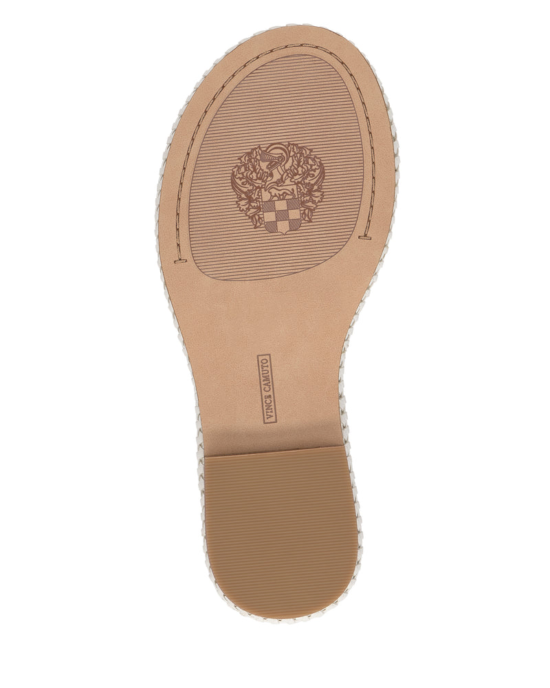 Bottom view of the Libahs Sandal by Vince Camuto in tan, featuring a textured-heel sole, crest emblem near the arch, and rectangular label—ideal for modern flat sandals with an adjustable ankle strap.