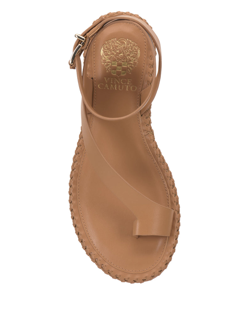 Top view of the Vince Camuto Libahs Sandal in tan, a modern flat with an asymmetrical design, toe loop, angled strap, braided edge accents, and gold logo on the insole.