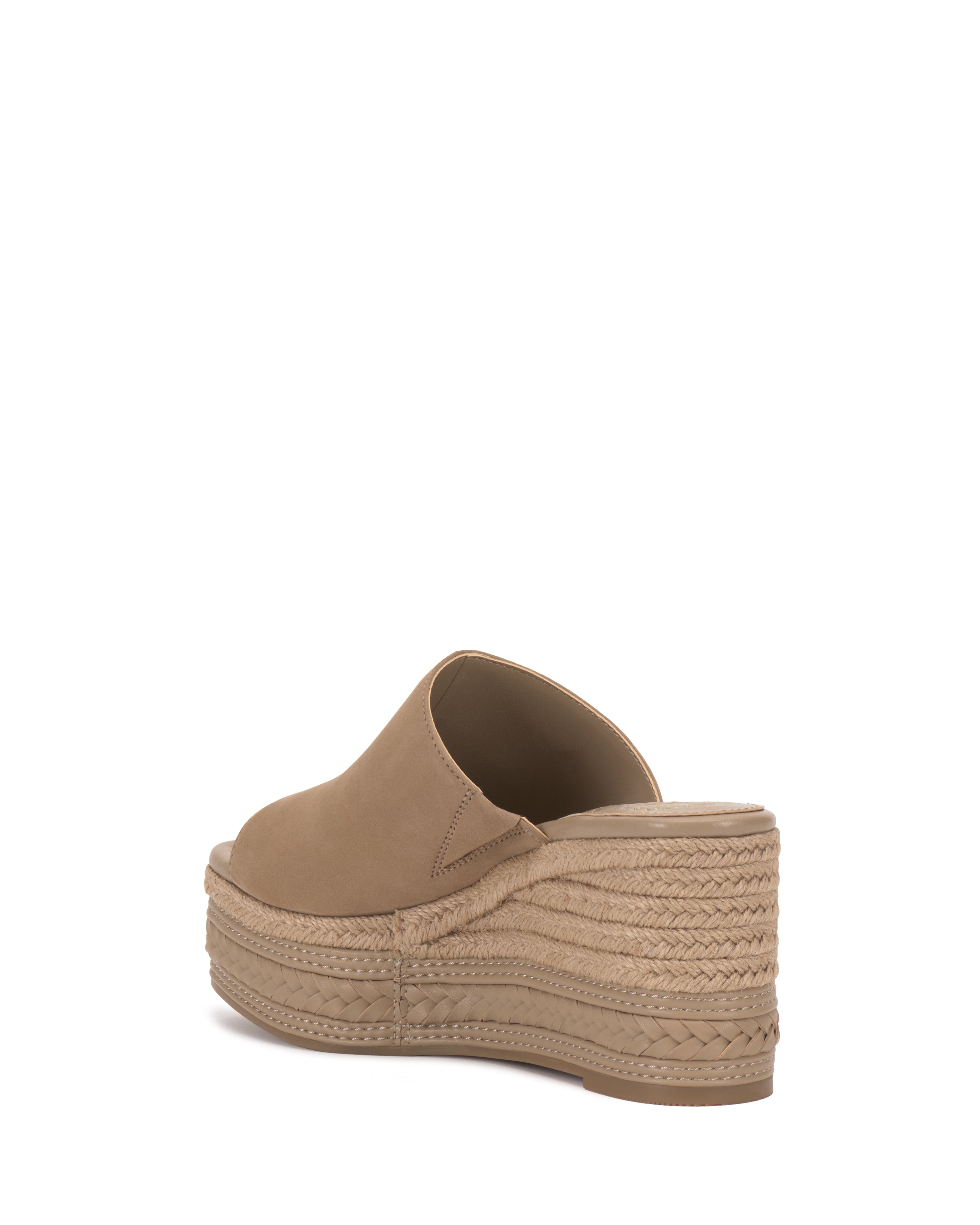 The Vince Camuto Lierna Espadrille Wedge Sandal is shown in tan, featuring a closed toe, braided espadrille platform sole, and mule design. Pictured from the back and side against a white background.