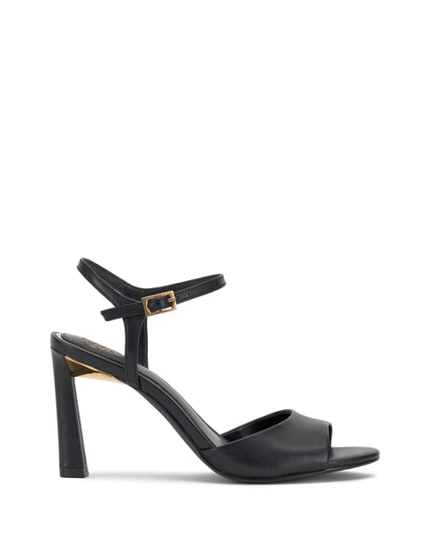 The Lilah Sandal by Vince Camuto features a black chunky heel, open toe, single front strap, closed heel, and ankle strap with a gold accent buckle. Its sleek, minimalist design adds elegance to any look.
