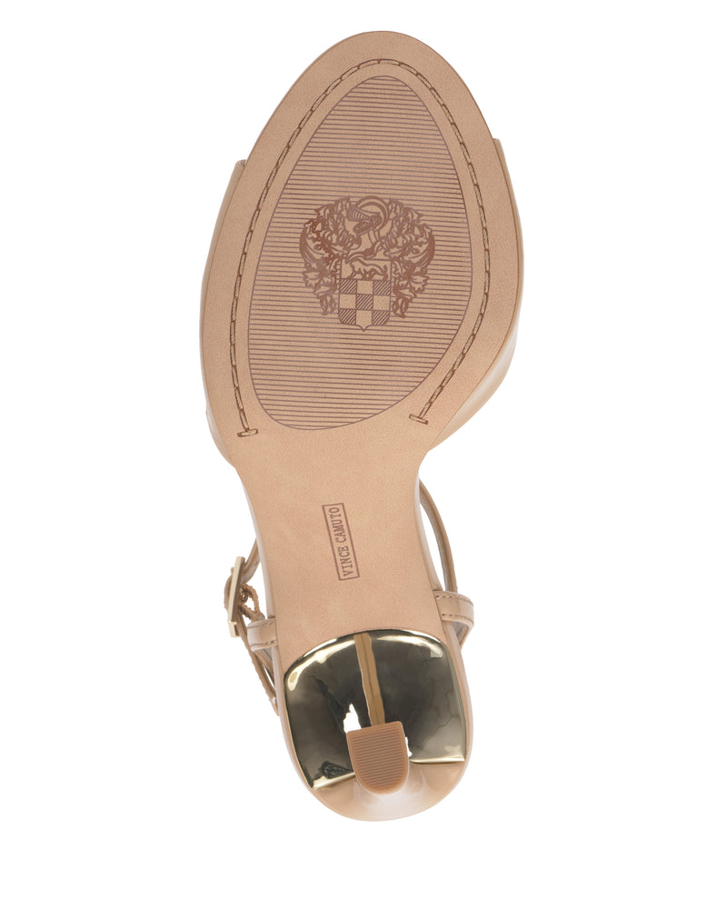 The image shows the beige sole of the Lilah Sandal by Vince Camuto, featuring a textured crest design, a gold-tipped metallic accent heel, and a visible Vince Camuto label near the arch.