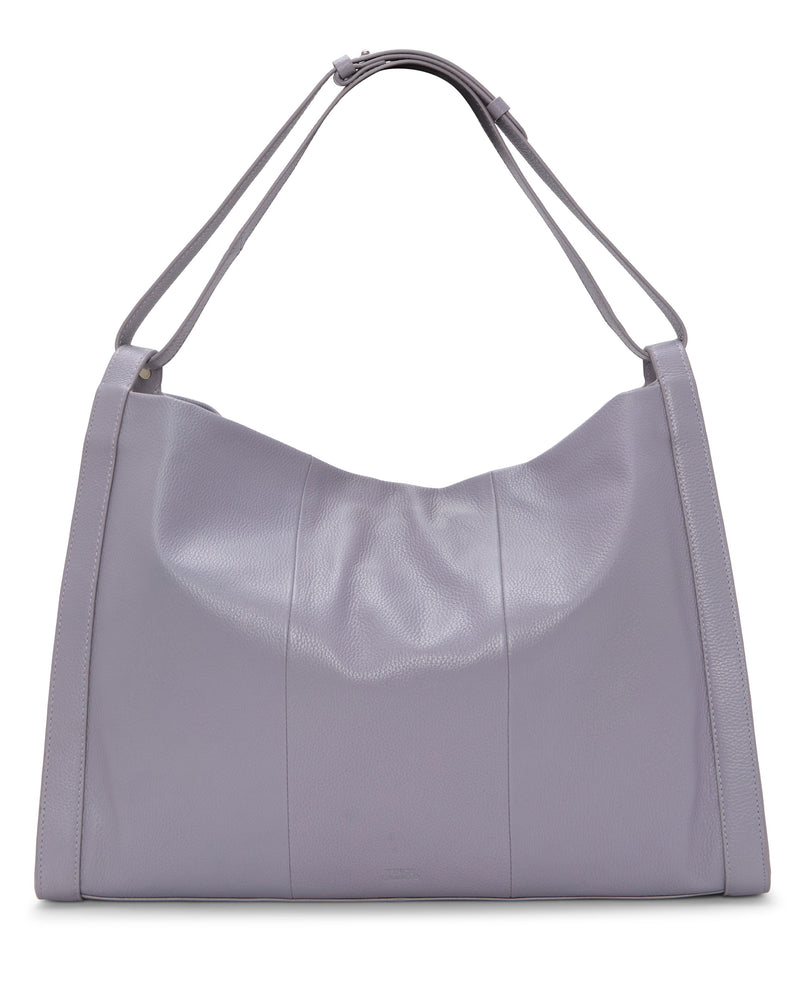 The Vince Camuto Lisha Tote Bag is a large lavender tote with a soft structure, two matching shoulder straps, minimal stitching, and a smooth, slightly textured finish—ideal for modern style and practical spaciousness.