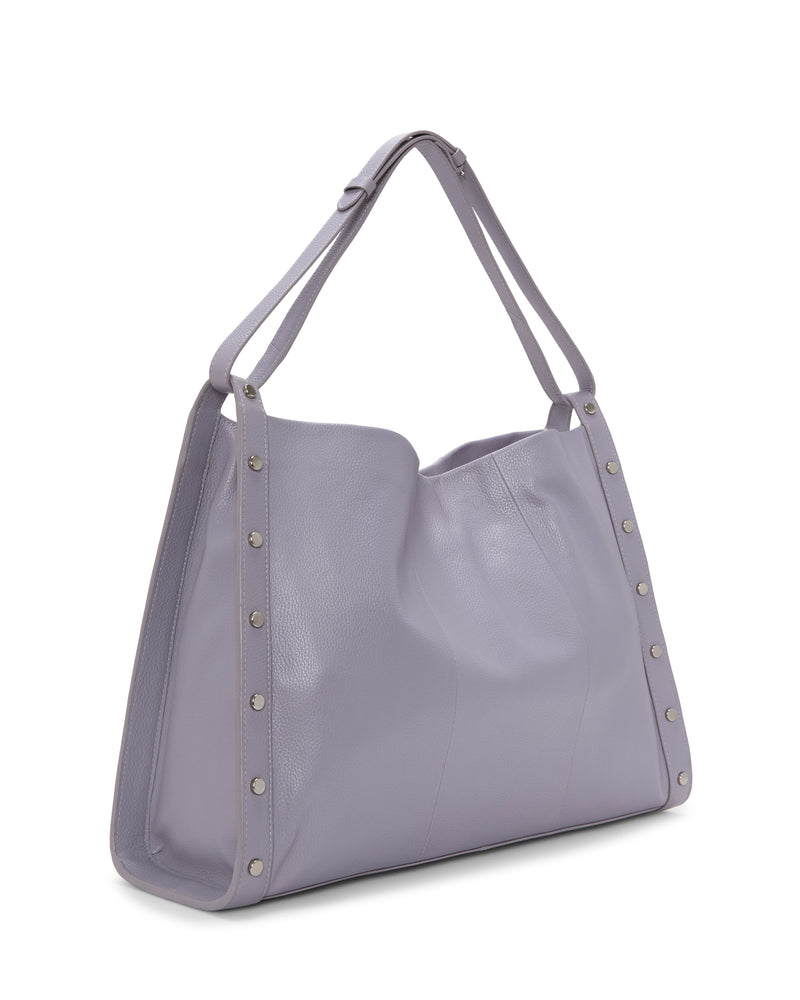 The Vince Camuto Lisha Tote Bag is a large, light purple leather shoulder bag featuring silver stud accents on the sides and double straps, delivering a modern tote style.