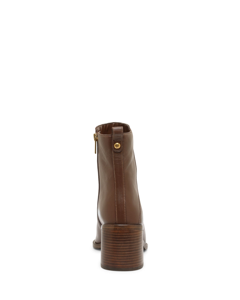 The Vince Camuto Lorelai Bootie is a brown leather ankle boot with a stacked block heel, shown from the back. It features a modern style complete with a side zipper and a small gold button near the top.