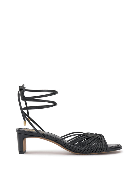 The Vince Camuto Lory Kitten Heel Sandal features black interwoven knotted straps, a low block heel, open toe, and wrap-around ankle tie for stylish elegance.