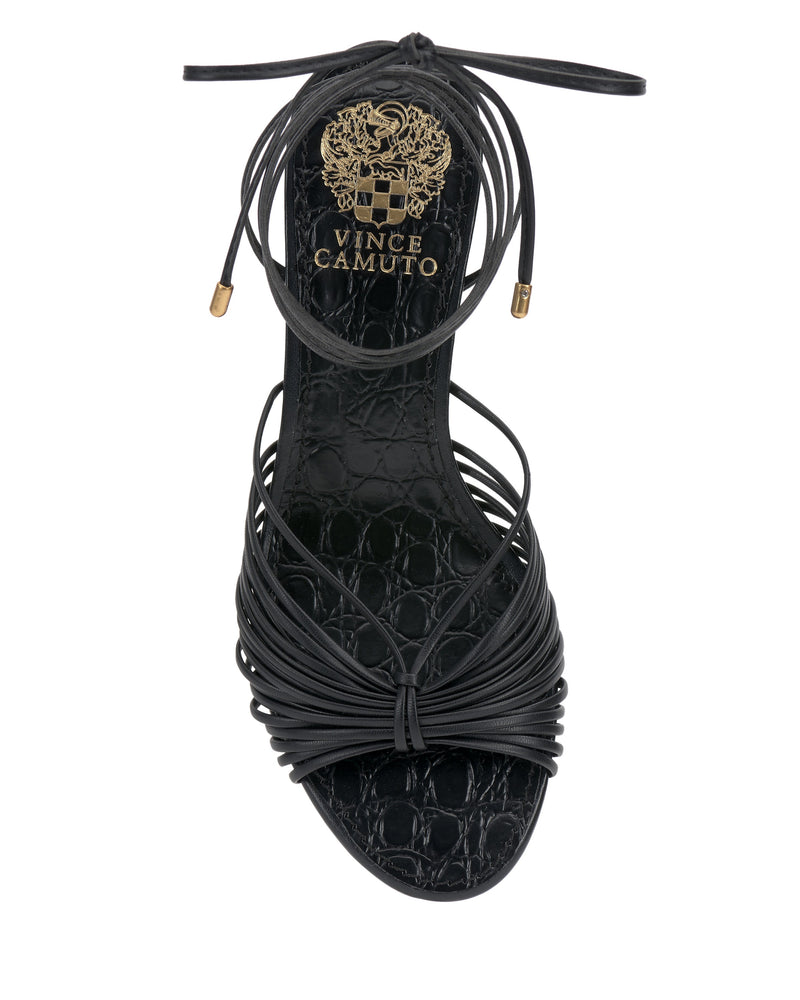 Top view of the Vince Camuto Lory Kitten Heel Sandal in black, featuring thin crisscross straps, ankle tie laces, a block kitten heel, and gold logo detailing on the textured insole.