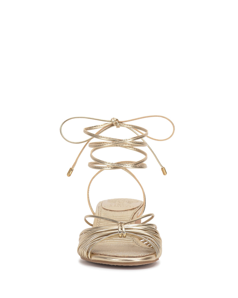 Front view of the Vince Camuto Lory Kitten Heel Sandal in gold, showcasing thin crisscross ankle tie laces, metallic accents, an open toe design, and a flattering low heel.