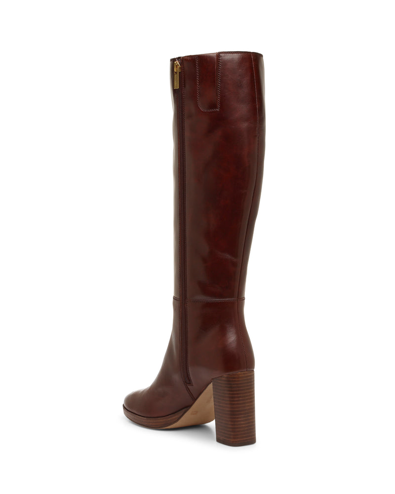A tall, brown leather knee-high Lucina Wide Calf Boot from Vince Camuto features a side zipper and a sturdy, high block heel. The boots are displayed upright on a white background, highlighting their stylish side profile.
