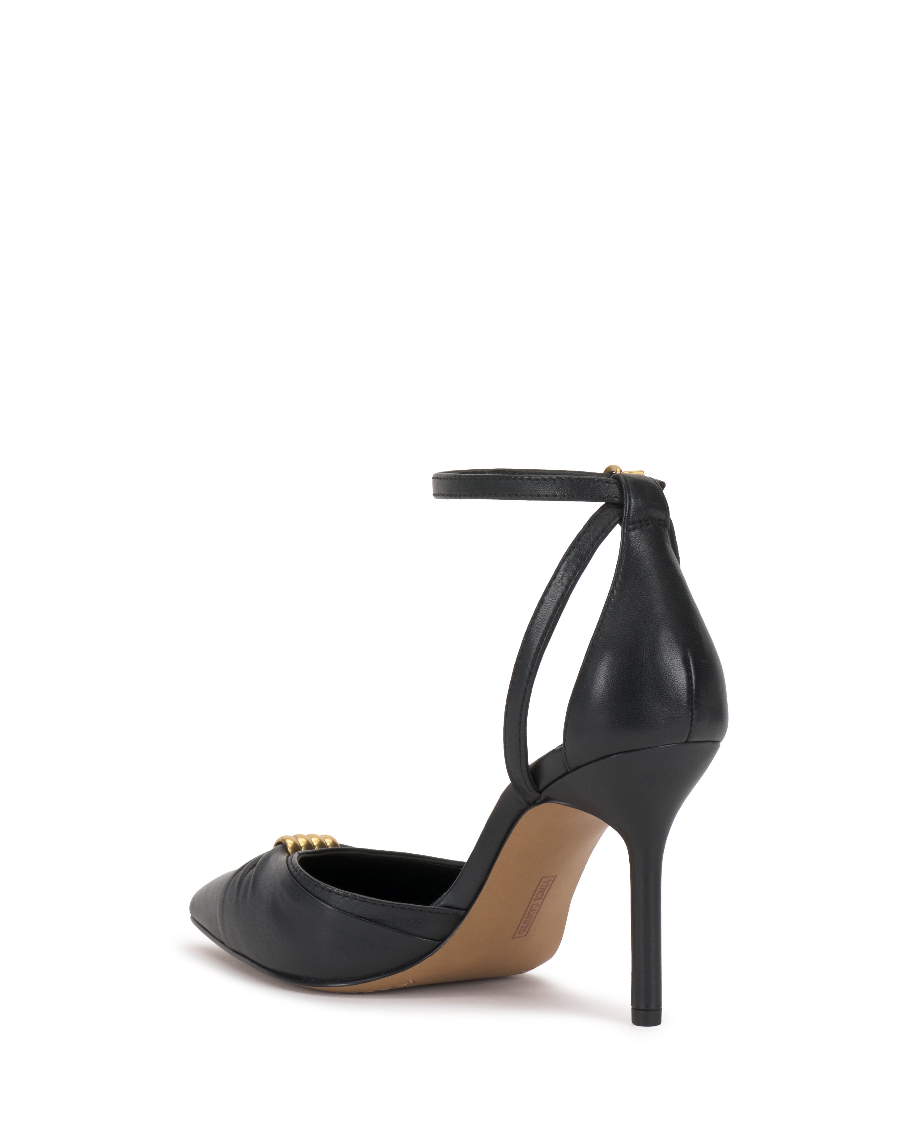 The Vince Camuto Mallie Pump is a black high-heeled shoe with a pointed toe, ankle strap, and gold buckle detail, shown from a rear side angle on a plain white background.