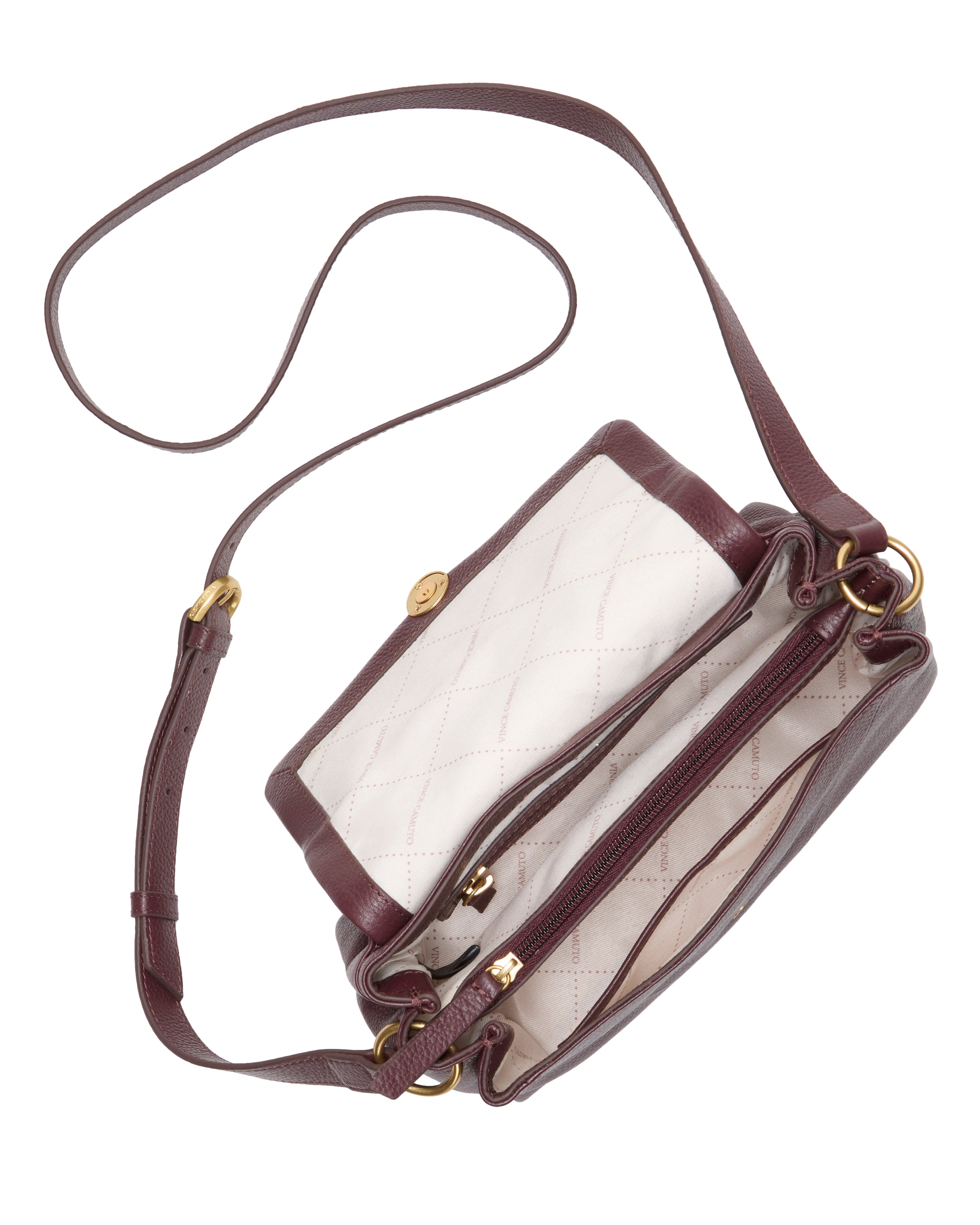 The Medna Crossbody Bag by Vince Camuto is a burgundy leather bag featuring an adjustable strap, gold hardware, and quilted white lining. It has two main compartments and a zippered pocket inside.